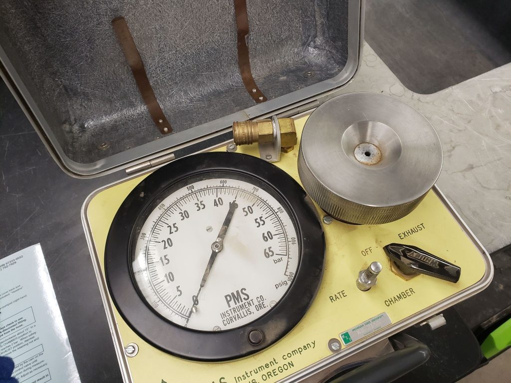 Close-up photo of an antique pressure chamber, also known as a pressure bomb, which is an instrument that can measure the approximate water potential of plant tissues.