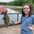A young girl smiles while an adult holds a fish that she caught in Wintergreen Lake.