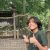 Student Cassius Caldwell, holds an eagle feather and gives a thumbs-up in front of the eagle enclosure at the W.K. Kellogg Bird Sanctuary.