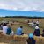 People sit in a half-circle on bales of straw listening to a presentation at the KBS Long-term Ecological Research program site.