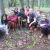 A group of participants in a past GALS program sit in a semicircle on the forest floor.